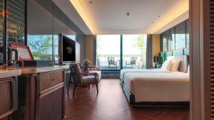 a bedroom with a bed and a desk with a television at Hotel Indigo Harbin Central Avenue by IHG in Harbin
