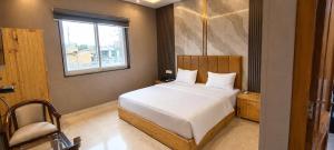 a bedroom with a bed and a window at The Pearl Hotel Rampur in Rāmpur