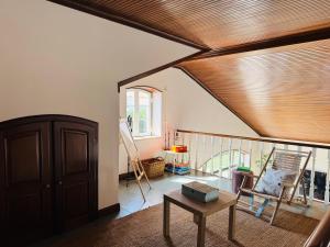 a living room with a wooden ceiling and a table at The Yellow Retreat in A dos Cunhados