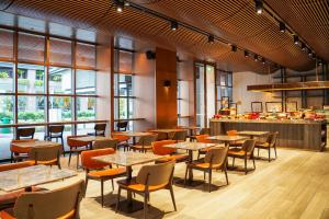 a restaurant with tables and chairs and windows at Oakwood Bencoolen Singapore in Singapore