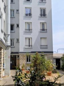 a tall white building with balconies on it at Bright Studio Near Paris & Disneyland in Neuilly-Plaisance