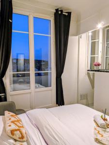 a bedroom with a bed and a window at Bright Studio Near Paris & Disneyland in Neuilly-Plaisance