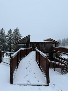 a bridge covered in snow in front of a building at Hoyo 5 Aldea de golf in San Martín de los Andes
