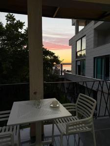 a white table and chairs on a balcony with the sunset at Villa Sunlight in Gonio