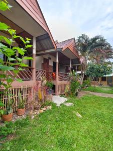 a house with a fence and plants in a yard at Pharit guesthouse in Pai