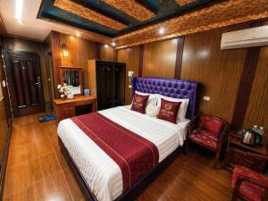 a bedroom with a large bed and a chair at Việt Anh Hotel in Sapa +6 photos