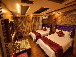 a hotel room with two beds and a television at Việt Anh Hotel in Sapa