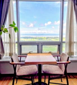 a table and two chairs in front of a large window at Cozy - Bright Studio in Incheon