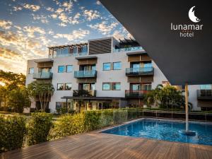a hotel with a swimming pool in front of a building at Hotel Lunamar in Beira