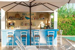 eine Bar unter einem Sonnenschirm neben einem Swimmingpool in der Unterkunft Creta Aquamarine Hotel in Platanes