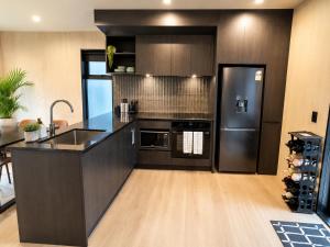 a kitchen with a stainless steel refrigerator and a sink at Relax on Remarkable in Queenstown