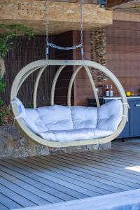 a swing on a patio with pillows on it at Villa Scappà Porticcio - Piscine & vue mer in Grosseto-Prugna