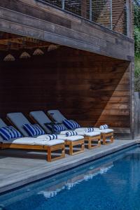 a group of chaise lounge chairs next to a swimming pool at Villa Scappà Porticcio - Piscine & vue mer in Grosseto-Prugna