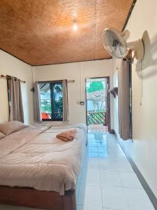 a bedroom with a large bed and a fan at Pharit guesthouse in Pai +37 photos