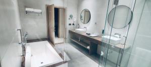 a bathroom with two sinks and a glass shower at Ira By Orchid Bhavnagar in Bhavnagar +45 photos