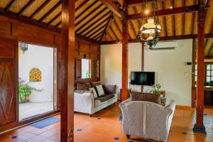 a living room with a couch and a tv at Cathaya Private Pool Villa - Limasan Padi in Langkawi Intl