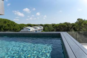 a swimming pool with blue water in front of a building at Don Cesar Palace in Bibione