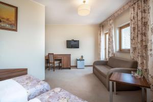 a hotel room with a bed and a couch at Łabędź Hotel Karczma in Iława