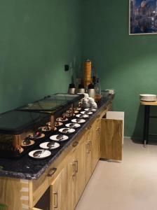 a kitchen with a counter with many plates on it at asar Varanasi Junction by Orion Hotels in Varanasi