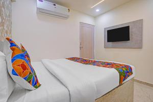 a bedroom with a bed and a tv on a wall at FabHotel Sky Inn I in Ahmedabad