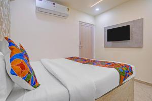 a bedroom with a bed and a tv on the wall at FabHotel Sky Inn I in Ahmedabad +25 photos