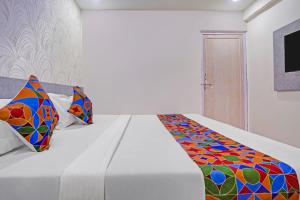a bedroom with a bed with a colorful comforter at FabHotel Sky Inn I in Ahmedabad