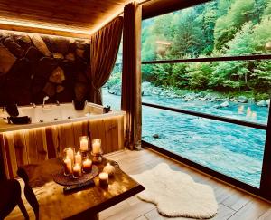 a room with a tub and a table with candles at Ayder Royal River Resorts - Bungalows & Hotels in Çamlıhemşin
