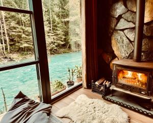 a fireplace in a room with a view of a river at Ayder Royal River Resorts - Bungalows & Hotels in Çamlıhemşin
