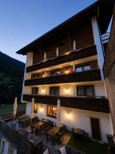 a building with tables and umbrellas in front of it at Hotel Buckelhof - See - Free Liftpass Summer in See
