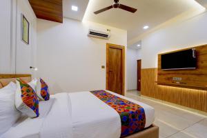 a bedroom with a bed and a flat screen tv at FabHotel Prime Hash Four in Ernakulam