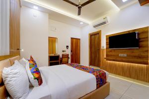a bedroom with a bed and a flat screen tv at FabHotel Prime Hash Four in Ernakulam