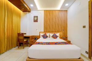 a bedroom with a bed and a desk and a table at FabHotel Prime Hash Four in Ernakulam +38 photos