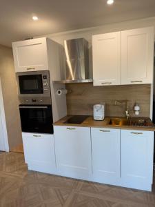 a kitchen with white cabinets and a sink at Suite Lisa in La Roche-Blanche