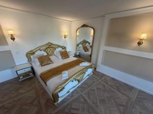 a bedroom with a large bed and a mirror at Suite Lisa in La Roche-Blanche