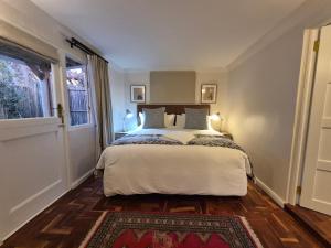 a bedroom with a bed and a window at Petit Ermitage in Franschhoek +58 photos