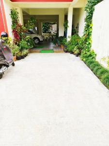 a house with a lot of plants and a driveway at The single room for two in Madikeri