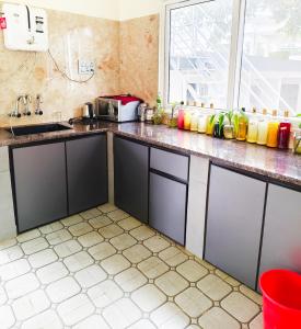 a kitchen with black cabinets and a sink at The single room for two in Madikeri +7 photos