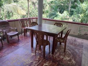 a wooden table and chairs on a porch at Miriswaththa resort in Deniyaya +6 photos