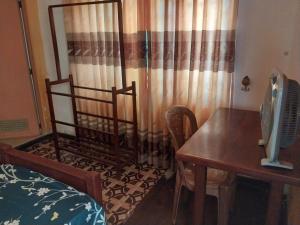 a bedroom with a bed and a desk and a table at Miriswaththa resort in Deniyaya