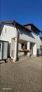 a white house with a balcony with flowers on it at Lopofa in Lunca de Sus