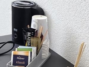 a table with a shelf with books and a drink at Pension La Casa in Radolfzell am Bodensee +40 photos