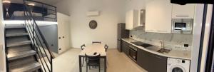 a kitchen with a table and a sink and a staircase at Vista Mare in Cipressa