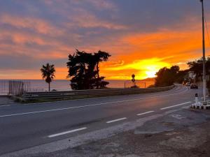 an empty road with the sunset in the background at Vista Mare in Cipressa