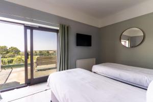 a bedroom with two beds and a large window at Bowood Park Hotel in Camelford +51 photos