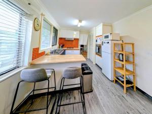 a kitchen with a counter and two stools in it at Star House in Mitcham