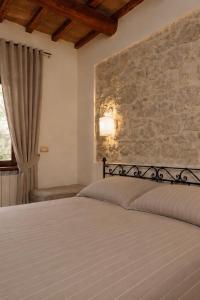 a bedroom with two beds and a stone wall at Agriturismo Pettino in Campello sul Clitunno +74 photos