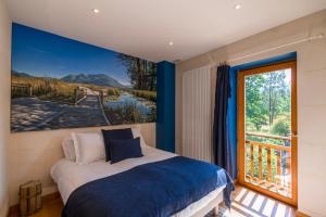 ein Schlafzimmer mit einem Bett und einem großen Fenster in der Unterkunft L'écrin des granges in Culoz + 88 Fotos