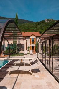 eine Terrasse mit Pool und ein Haus in der Unterkunft L'écrin des granges in Culoz