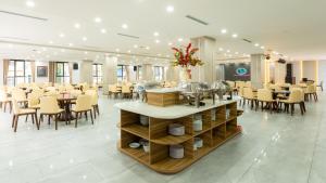 a restaurant with tables and chairs in a room at catba new city hotel in Cat Ba