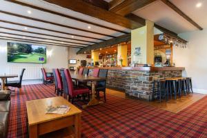 a bar in a restaurant with tables and chairs at Bowood Park Hotel in Camelford